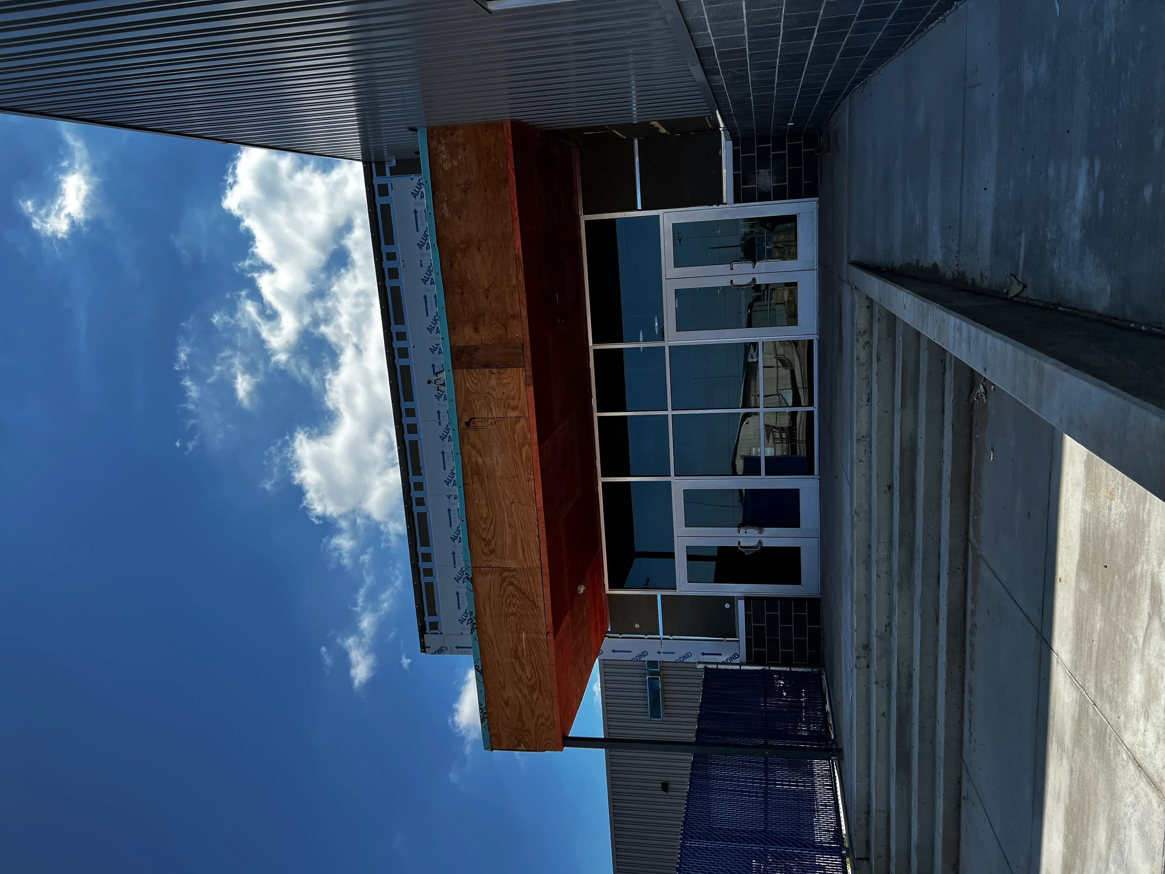 Metal commercial building with corrugated steel roof and multi-pane window installation