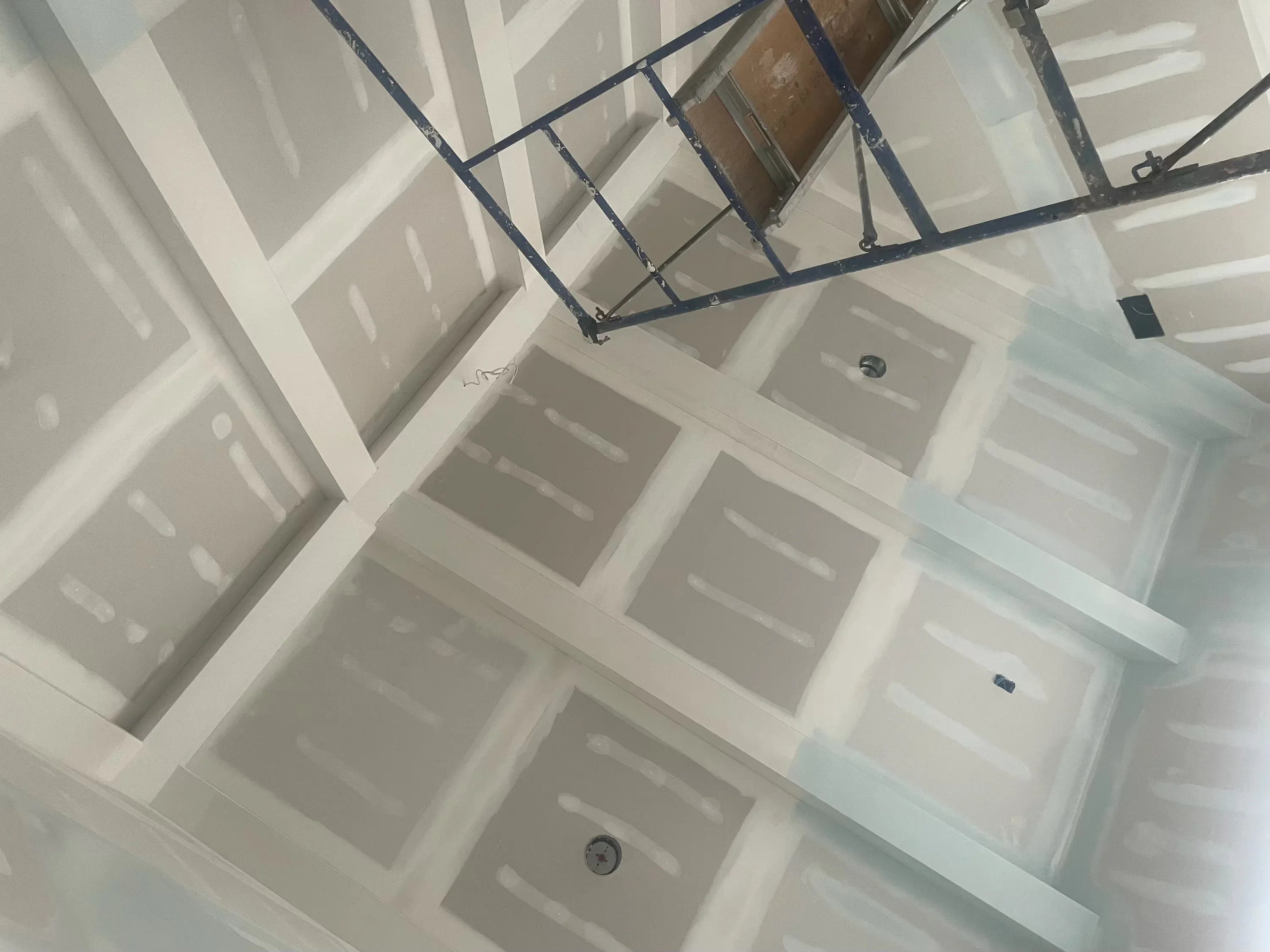 Drywall ceiling installation with recessed boxes and metal framing in progress