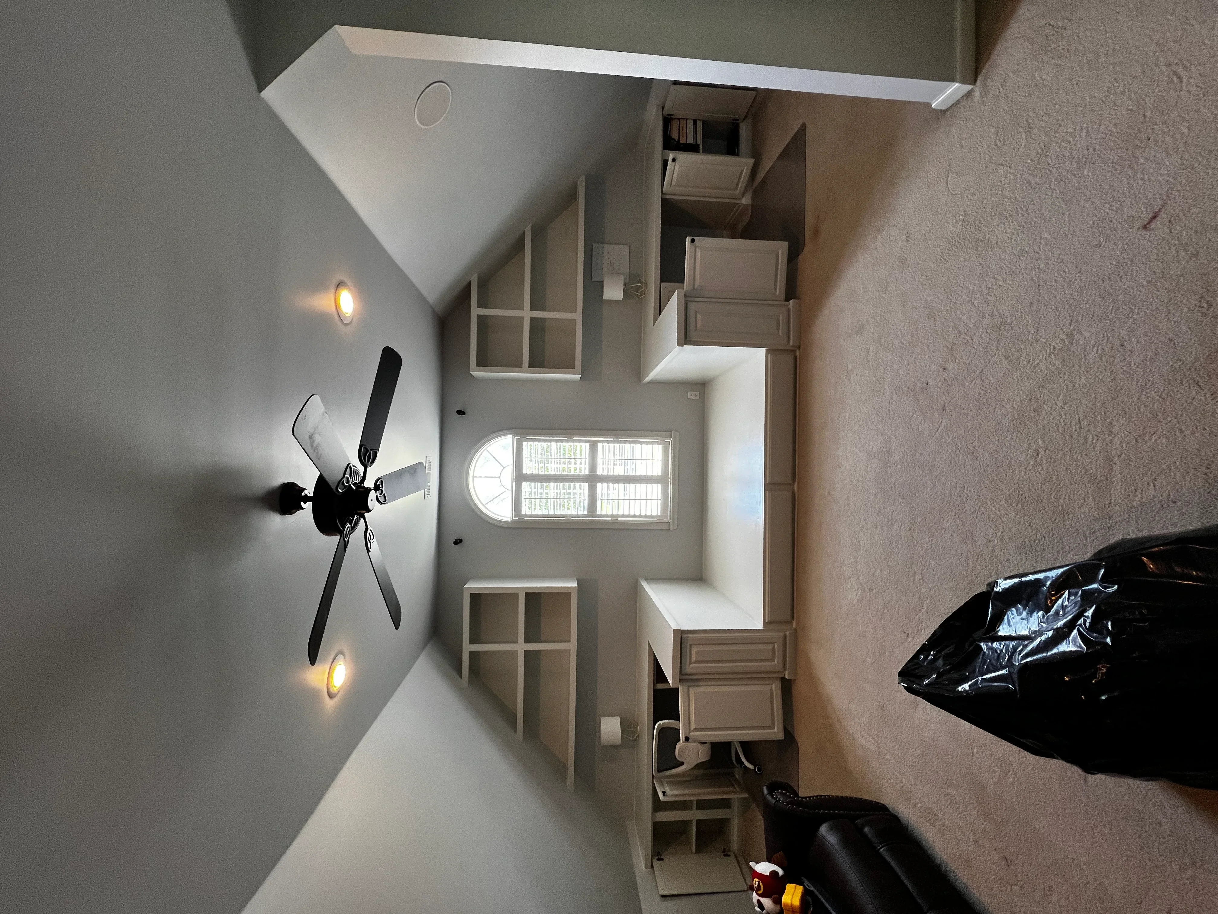 Renovated entryway with white drywall, built-in shelving, and transom window