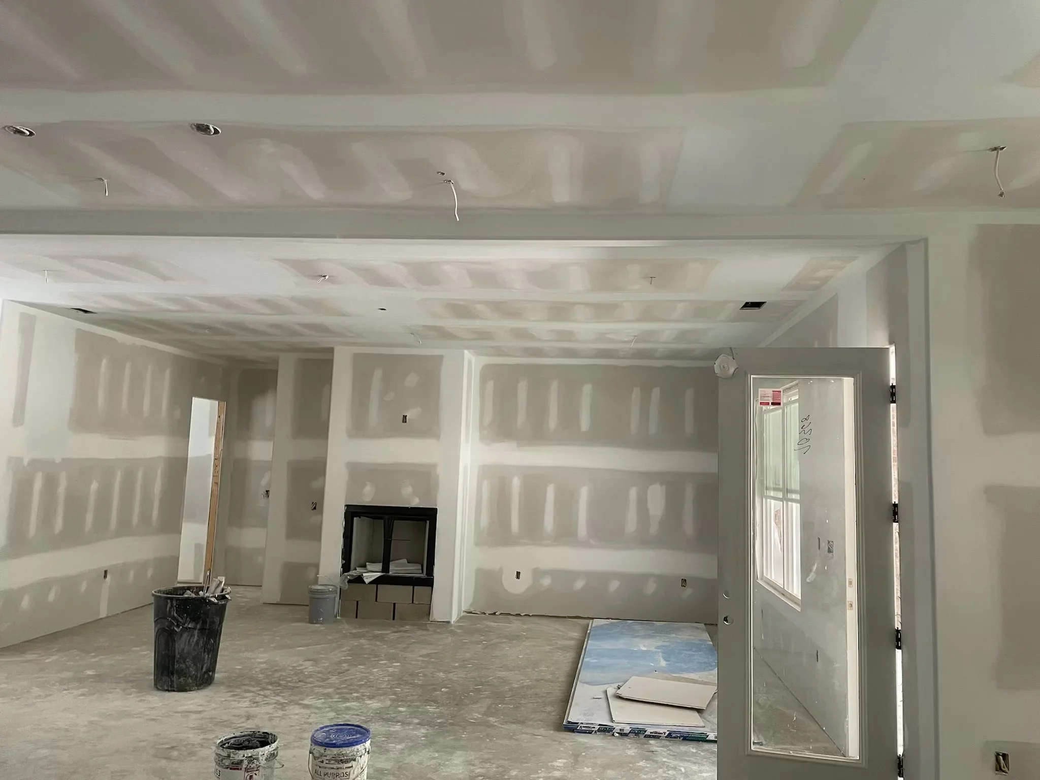 Interior drywall installation with taped walls and ceiling in multi-room residential space