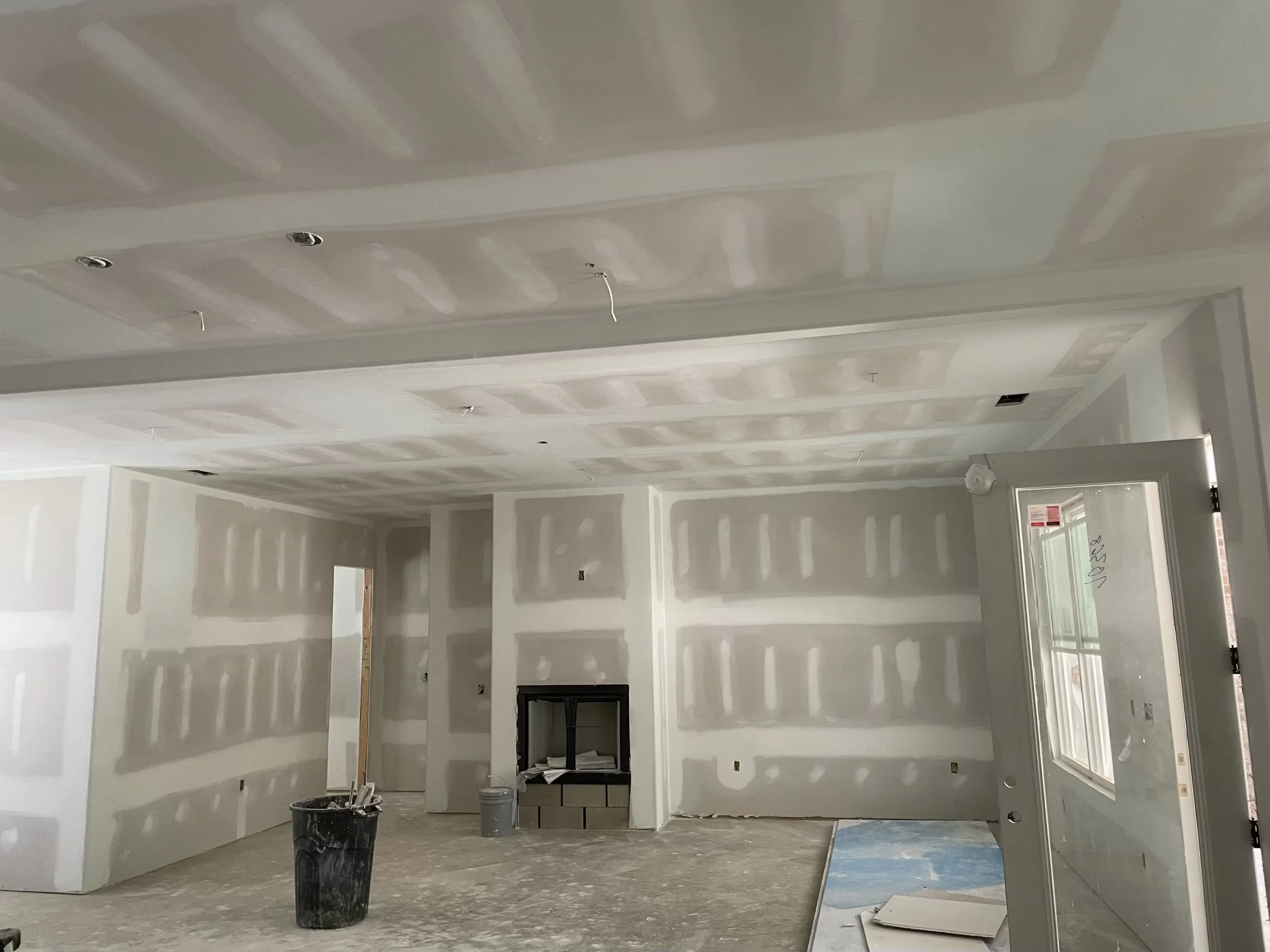 Interior drywall installation with multiple room framing and recessed ceiling lights