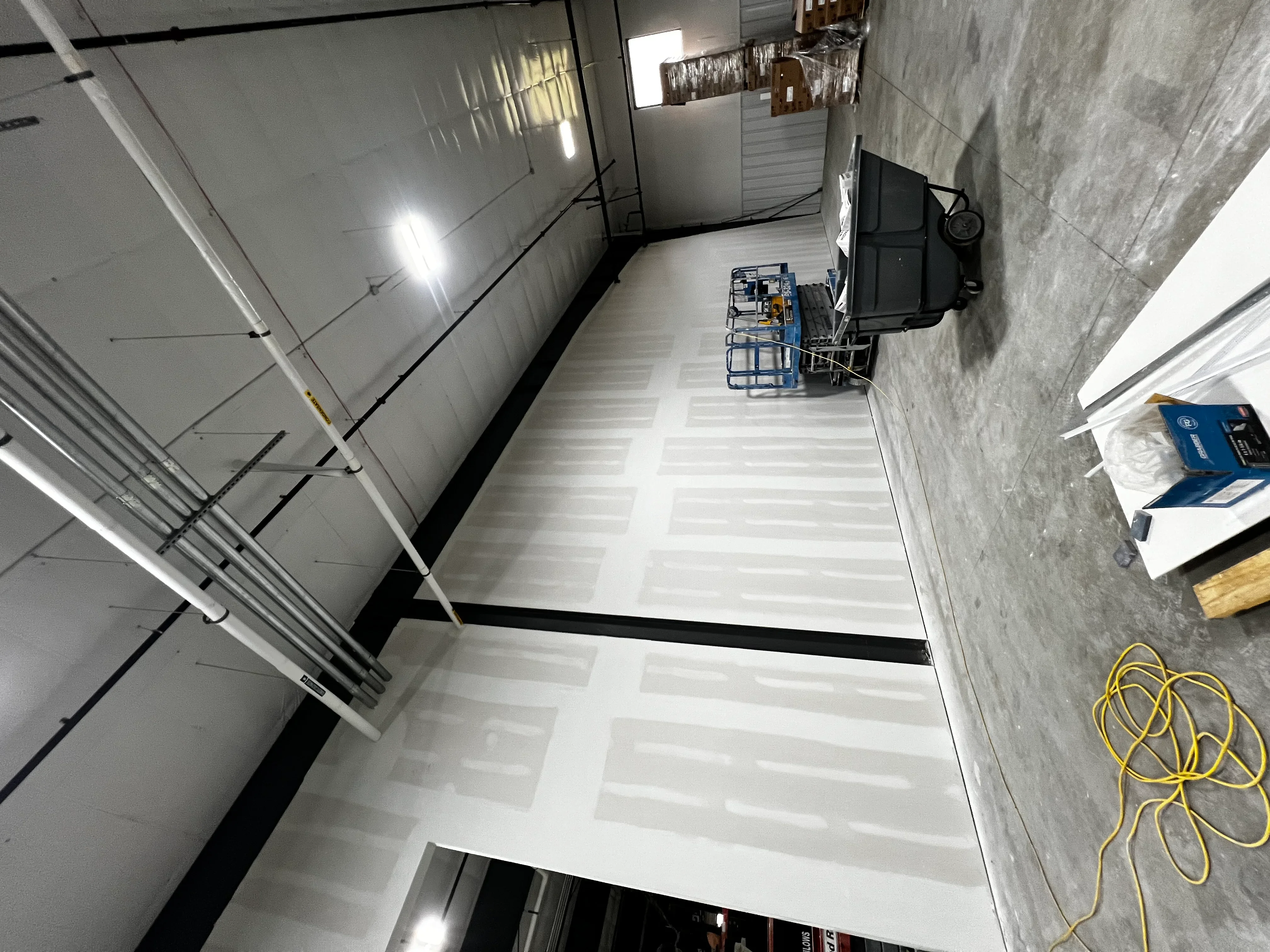 Commercial interior drywall installation with finished seams and recessed lighting in Nesbit