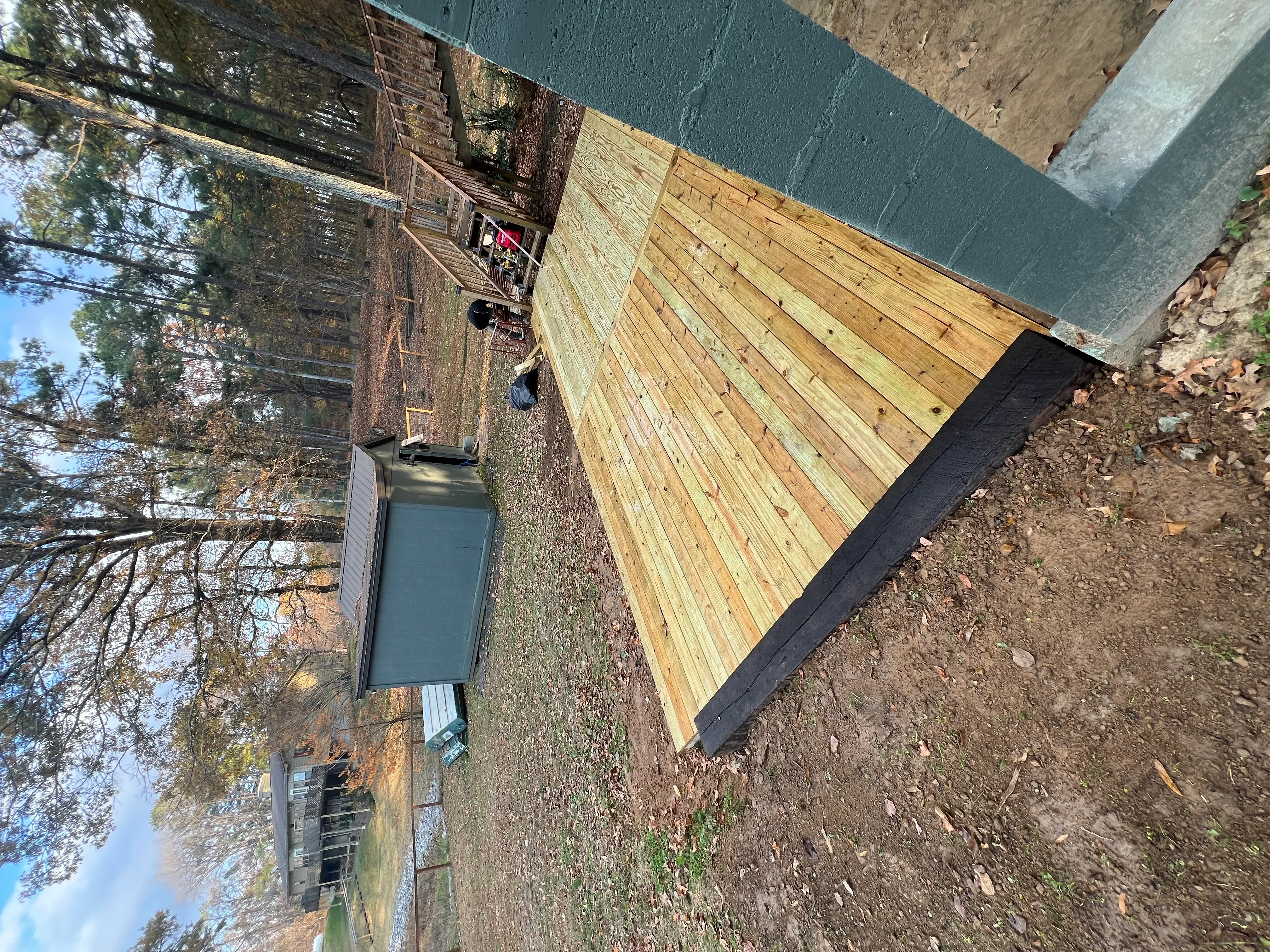 New wooden deck with pressure-treated boards and black trim edge on residential property
