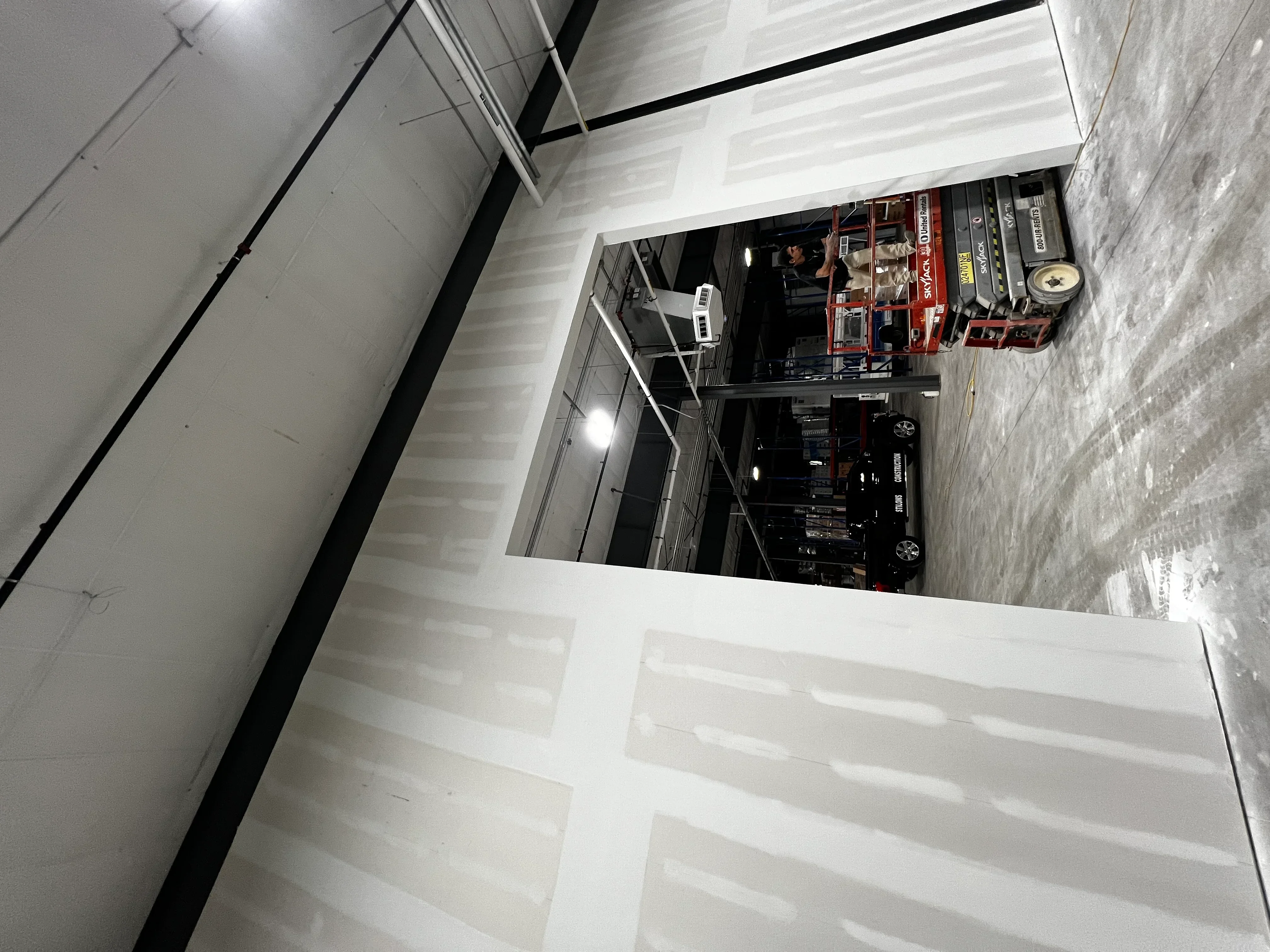 Commercial interior with drywall-finished walls and metal stud framing in warehouse space